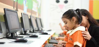 跨境电商卖家在电脑前操作云途物流批量查询界面，屏幕显示多个订单追踪状态，办公室环境专业感